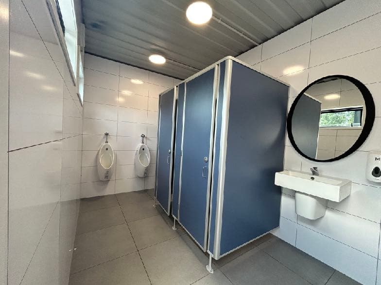Public washroom with Hydratile-lined walls and cubicles — high-use durability