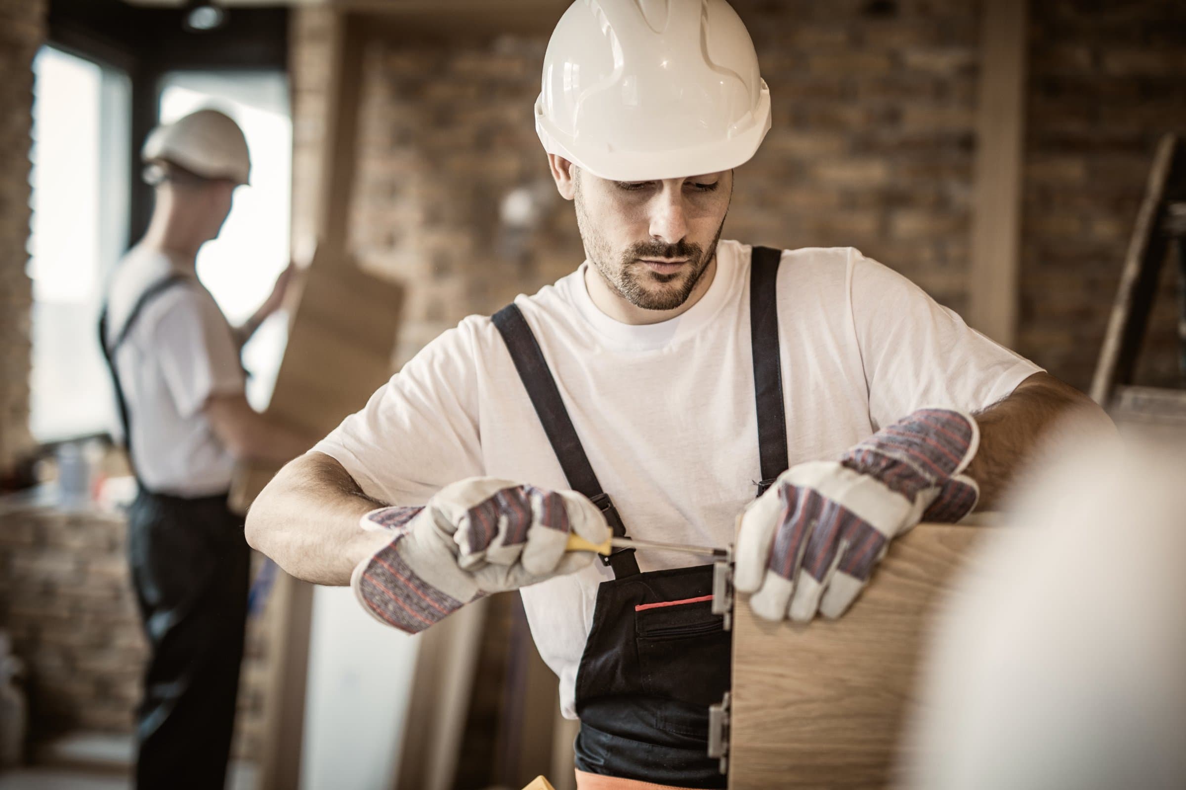 Tradesperson fitting panel hardware on site
